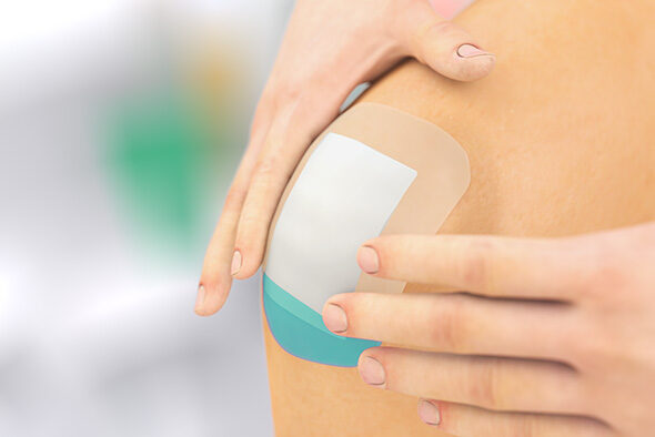 Person placing a Sorbact Secure dressing the knee.